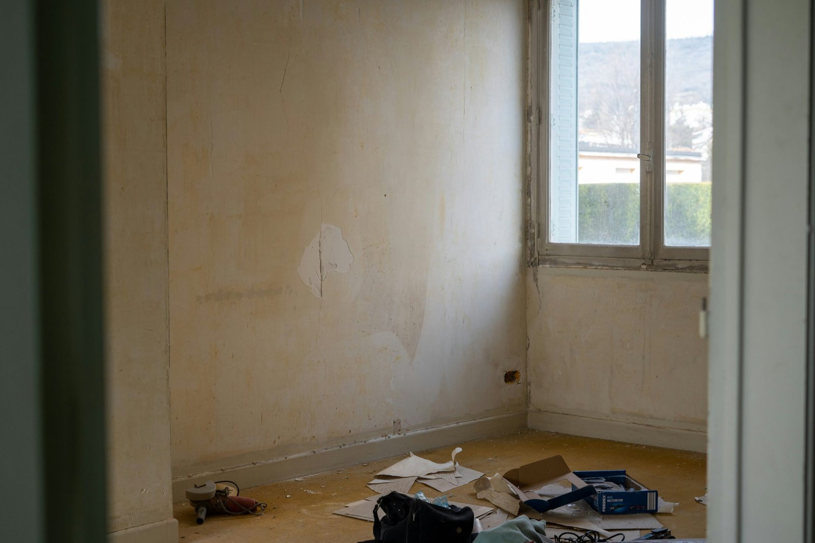 a room with a window and a bunch of items on the floor